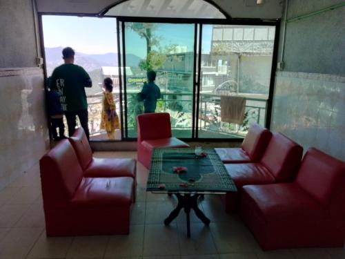 ein Wohnzimmer mit zwei roten Sofas und einem Tisch in der Unterkunft Murree Continental Hotel in Murree
