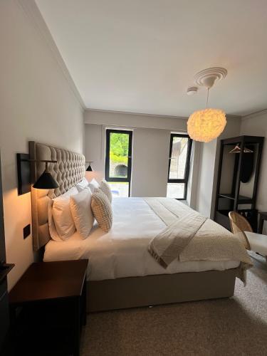 a bedroom with a large bed with white sheets and pillows at The Glen Quarter in Kinsale