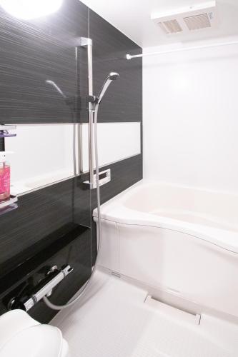 a bathroom with a shower and a bath tub at Apartment Hotel Tenjin TUMUGU in Fukuoka