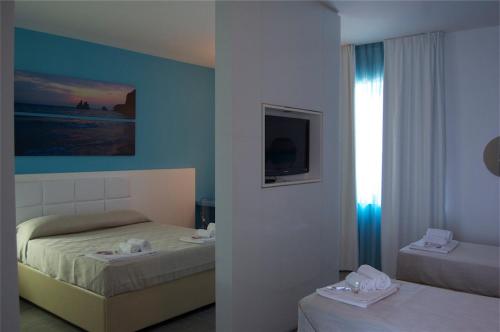 1 dormitorio con 2 camas y ventana en Motel S.16, en Muro Leccese