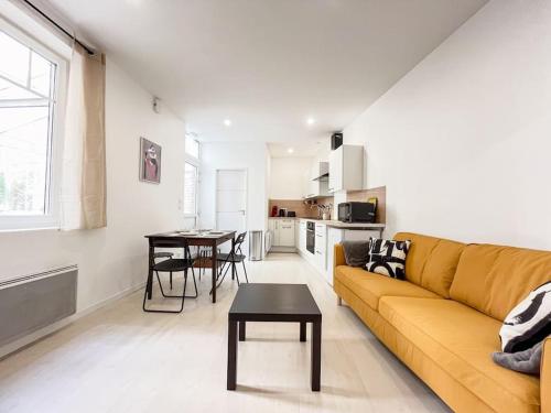 un salon avec un canapé jaune et une table dans l'établissement Le 3 cailloux / 2 Chambre *Hyper centre*, à Amiens