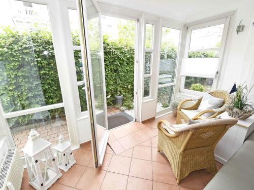 einen Wintergarten mit einer Glastür, die auf eine Terrasse führt in der Unterkunft Haus "Concordia" in Binz - WG 02 "Seedorf" mit Terrasse, strandnah in Binz