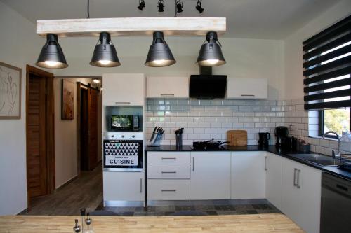 a kitchen with white cabinets and black appliances at Lux Penthouse Apartment 3 bedrooms Quatre Bornes in Quatre Bornes