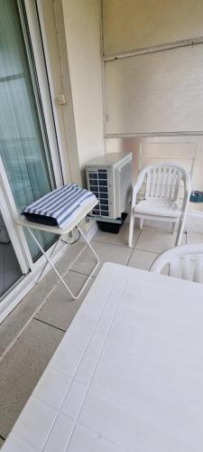 un balcon avec un radiateur, une table et une chaise dans l'établissement Studio plage de sable, à Antibes