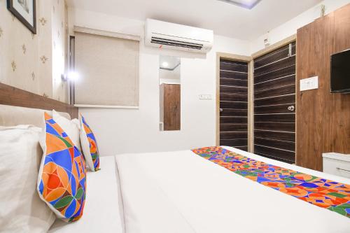 a white room with a bed and a tv at FabHotel Shree Ram Palace in Indore