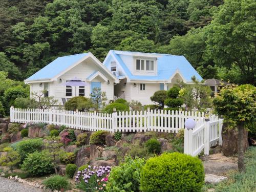 a white house with a white picket fence at Soomhouse in Danyang