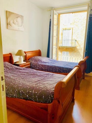 une chambre avec deux lits jumeaux et une fenêtre dans l'établissement Appart - Central - Cœur historique, à Sarlat-la-Canéda