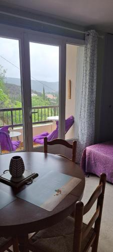 une table de salle à manger avec vue sur un balcon dans l'établissement Frais et bien orienté confortable joli studio Phannie proche cure, à Amélie-les-Bains-Palalda