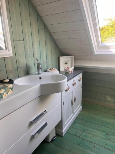 une salle de bain avec un lavabo blanc et une fenêtre dans l'établissement Le penty, à Ploemeur