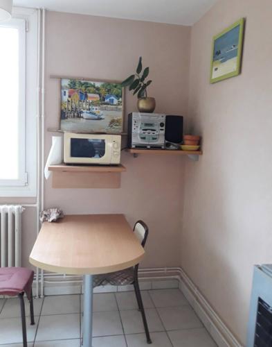 une petite cuisine avec une table et un micro-ondes dans l'établissement appartement Velotte, à Besançon