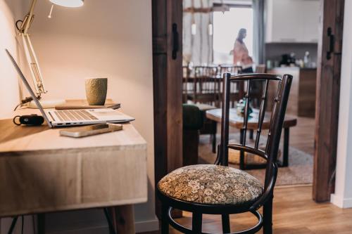 a chair sitting next to a desk with a laptop at Dzikowiejsko in Bardo