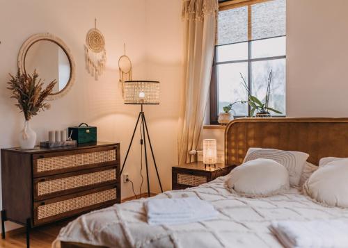 a bedroom with a bed with a dresser and a window at Dzikowiejsko in Bardo