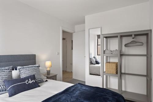 ein weißes Schlafzimmer mit einem Bett und einem Spiegel in der Unterkunft Modern Apartment Private Parking Central Taunton in Taunton