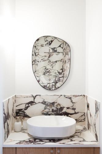 une salle de bain avec un lavabo et un miroir au mur dans l'établissement Sublime appartement luxe Paris Haut-Marais AC, à Paris