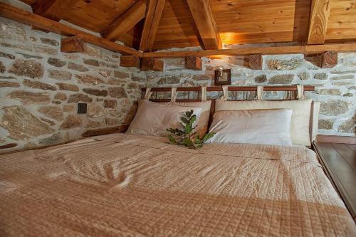 a bedroom with a large bed in a stone wall at Μountain Whispers in Mouresi