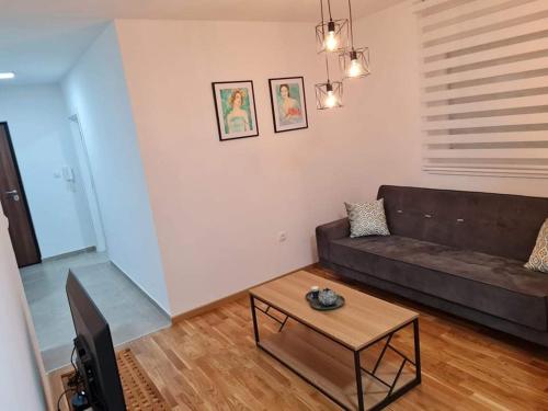 a living room with a couch and a coffee table at Apartman Mirabell, Doboj in Doboj