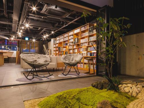 um quarto com duas cadeiras e uma estante de livros em Giappo Franca Kyoto em Quioto
