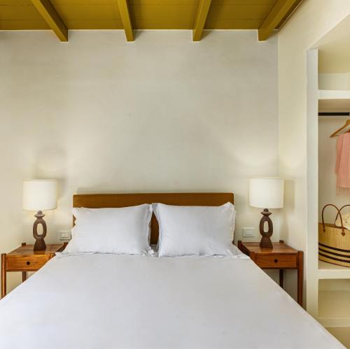 una camera da letto con un grande letto bianco con due lampade di Teresa Spetses a Spetses