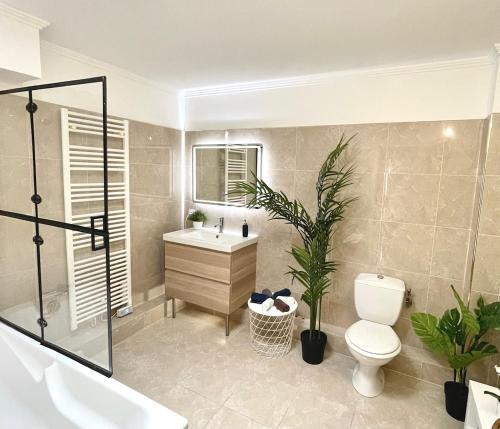 une salle de bain avec toilettes, lavabo et baignoire dans l'établissement Appartement Luxueux 