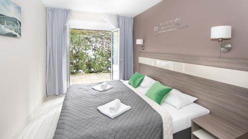 a bedroom with a bed with green and white pillows at Bormio - Czarna Góra Resort by Sun & Snow z nielimitowanym basenem in Sienna