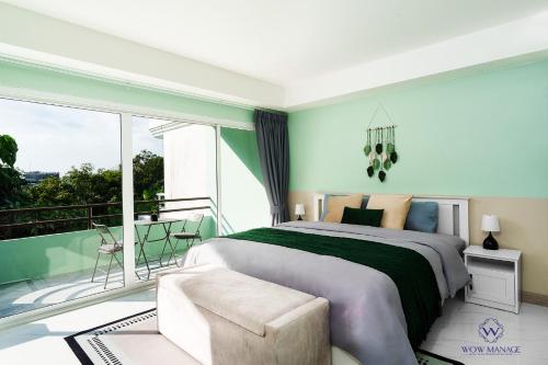 a bedroom with a large bed and a balcony at Enjoy Sunset Rainbow Alley - WOW Townhouse at Patong Hill in Patong Beach