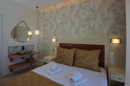 a bedroom with a bed with two towels on it at Pension Votsi in Votsi