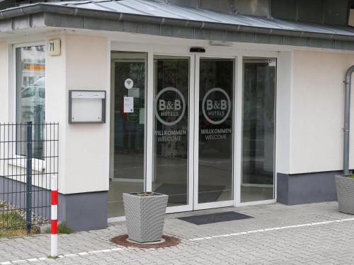 柏林的住宿－B&B HOTEL Berlin-Adlershof，街道上装有玻璃门的商店前