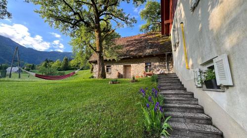 a house with a hammock in front of a yard at Apartments Mala Korita Soče in Soča