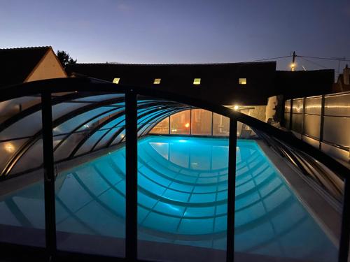 - une piscine au-dessus d'un bâtiment la nuit dans l'établissement Gîtes les trois clefs, à Maslives