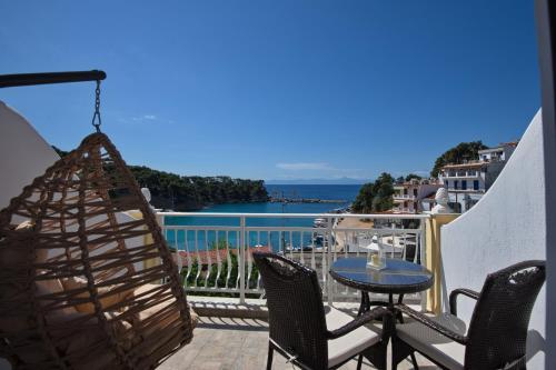 a balcony with a table and chairs and a view of the water at Pension Votsi in Votsi