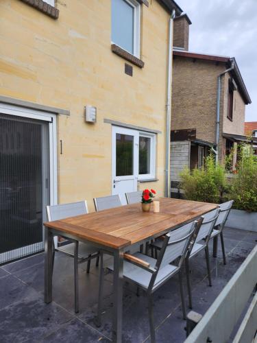een houten tafel en stoelen op een patio bij Casa Cinco in Valkenburg