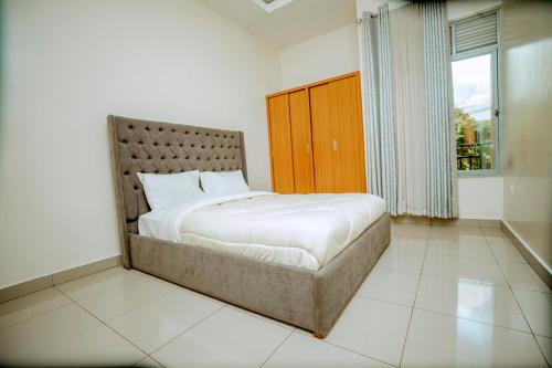 een slaapkamer met een bed en een groot raam bij Kigali Wings Apartment 4 in Kigali