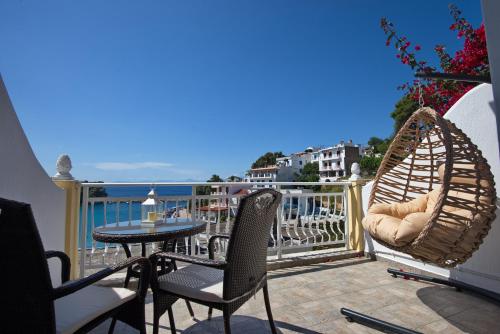 a balcony with a table and chairs and a view of the ocean at Pension Votsi in Votsi