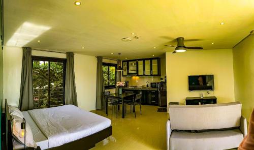a living room with a bed and a kitchen at The Pacific Coast in Boracay