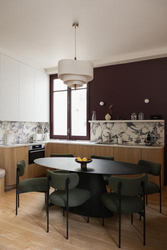 une cuisine avec une table et des chaises dans une pièce dans l'établissement Sublime appartement luxe Paris Haut-Marais AC, à Paris