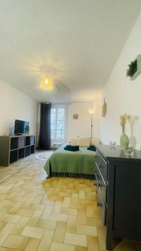 - une chambre avec un lit vert et du parquet dans l'établissement Charmant studio Mistral - Acenseur - Centre-ville, à Digne-Les-Bains