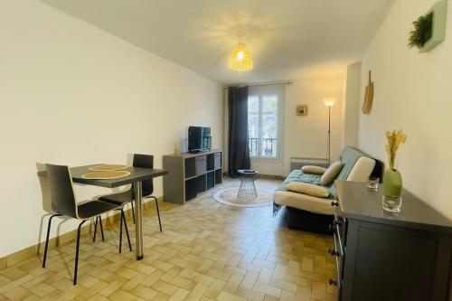 un salon avec un canapé et une table dans l'établissement Charmant studio Mistral - Acenseur - Centre-ville, à Digne-Les-Bains