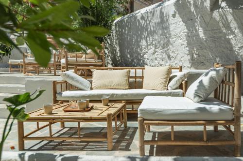 un patio con bancos y una mesa con almohadas en Teresa Spetses en Spétses