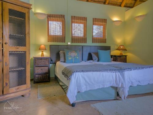 a bedroom with a large bed in a room at Hornbill House @ Zebula in Mabula