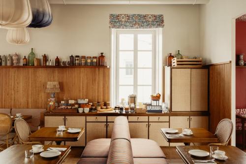 a restaurant with tables and chairs and a window at La Mission Hôtel & SPA - l'île d'Yeu in L'Ile d'Yeu