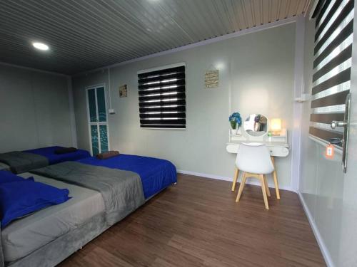 um quarto com uma cama, uma secretária e uma cadeira em Redang Bro Roomstay em Setiu