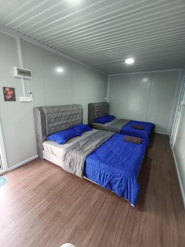 a bedroom with two beds in the corner of a room at Redang Bro Roomstay in Setiu