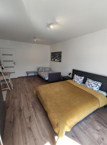 um quarto com uma cama grande e um sofá em Apartament Wrzosowy Balkon Łódź em Lódź