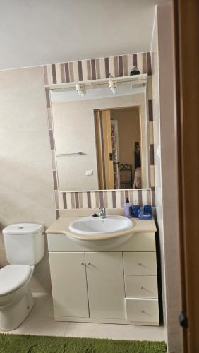 a bathroom with a sink and a toilet and a mirror at Beach House Lanzarote in Arrecife