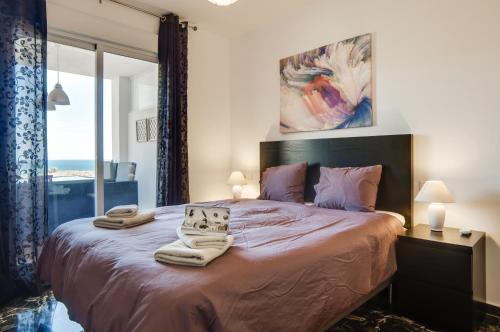 a bedroom with a large bed with two towels on it at Carvajal Luxury Apartments - Free Parking in Fuengirola