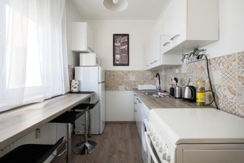 Una cocina con gabinetes blancos y un refrigerador blanco. en Lunar Love Apartment, en Budapest