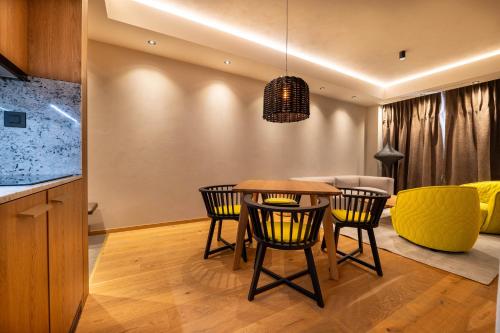 a kitchen and dining room with a table and chairs at Swissôtel Damian Jasna in Demanovska Dolina