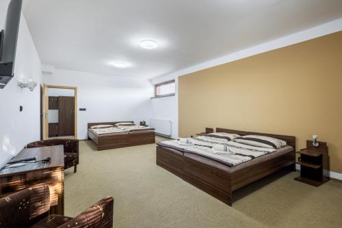 duas camas num quarto com duas cadeiras em Marina Labe em Píšťany