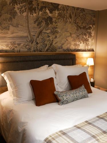 a bed with white pillows and a painting on the wall at Queens Head Inn & Restaurant in Hawkshead