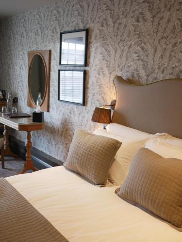 a bedroom with a bed and a desk with a mirror at Queens Head Inn & Restaurant in Hawkshead